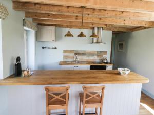 LoftusにあるField Cottageのキッチン(木製カウンタートップ、椅子2脚付)