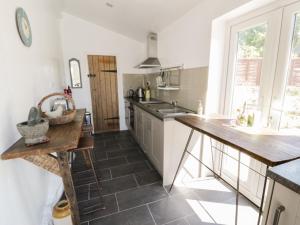 a kitchen with a counter and a table in it at 2 Borthwen Cottages in Dyffryn