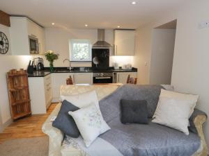 a living room with a couch and a kitchen at The Granary Loft in Sunbrick