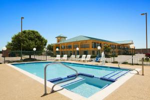 a swimming pool in front of a building at Super 8 by Wyndham Grand Prairie Southwest in Grand Prairie