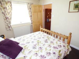 a bedroom with a bed with a floral bedspread at The Packing House in Severn Stoke