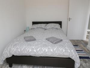 a bedroom with a bed with two pillows on it at The Studio The Old Post Office in Cemaes Bay
