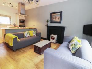 a living room with two couches and a kitchen at 4 Wheatsheaf Yard in Morpeth
