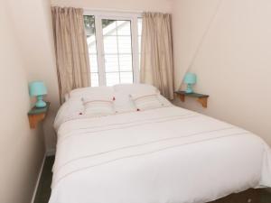 LlanddonaにあるThe Cottage at Wylan Hallの窓付きの客室の白いベッド1台