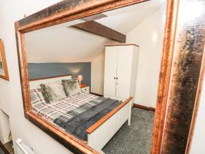 um quarto com uma cama e um espelho em Old Hall Barn em Hope