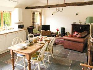 a kitchen and living room with a table and chairs at Ginny's Barn in Askham