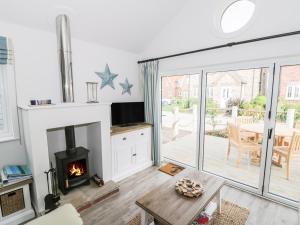 a living room with a fireplace and a table at Beach Walk in Reighton