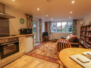 une cuisine avec une table et un salon dans l'établissement Sunnyside Garden Cottage, à Husthwaite
