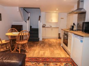 a kitchen and living room with a table and chairs at Sunnyside Garden Cottage in Husthwaite