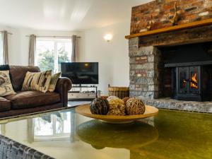 a living room with a fireplace and a table with eggs on it at Nairn in Braunton