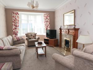 a living room with a fireplace and a television at 75 Mansfield Road in Ault Hucknall