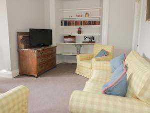 uma sala de estar com dois sofás e uma televisão em Housekeeper's Rooms em Pathhead
