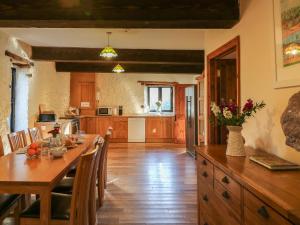 a kitchen with a wooden table and a dining room at Carthorse Cottage in Luton