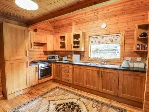 スランベドルにあるSunset Lodge 6のキッチン(木製キャビネット、シンク、窓付)