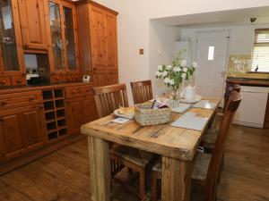 Whitfield Cottage 21 Silver Street في Wolsingham: مطبخ مع طاولة خشبية مع كراسي وغرفة طعام