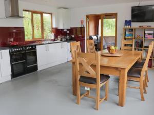 a kitchen with a wooden table and some chairs at Rolling Hills in Newcastle