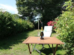 a wooden table with a bottle of wine and a glass at Witchelm House in Inverness