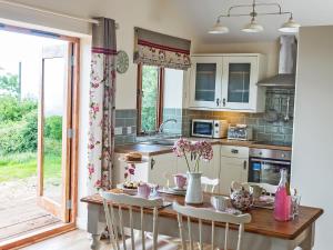a kitchen with a table with flowers on it at Stoney-Brook Lodge in Farden