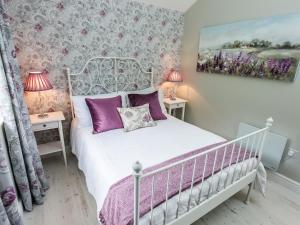 a bedroom with a white bed with purple pillows at Stoney-Brook Lodge in Farden