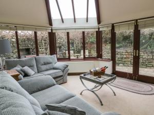 a living room with couches and a table and windows at Hill Bank in Lupton