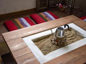 a wooden table with a pot in the sand at Guest Cafe Kuchikumano in Kamitondacho