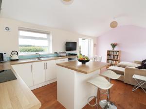 an open kitchen and living room with a couch at Bowler Yard Cottage in Sookholme