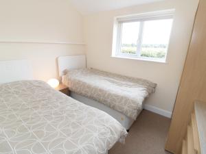 a bedroom with two beds and a window at Bowler Yard Cottage in Sookholme