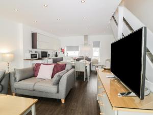 a living room with a tv and a couch and a table at Harbourside House in Haverigg