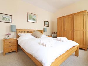 a bedroom with two white beds and a wooden cabinet at Parula in St Just