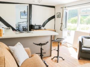 a kitchen and living room with a counter and chairs at The Old Beams at Pont y Forwyn in Llansantffraid-ym-Mechain