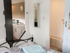 a room with a bed and a mirror and a kitchen at The Old Beams at Pont y Forwyn in Llansantffraid-ym-Mechain