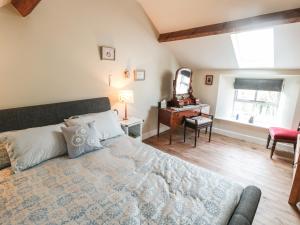 a bedroom with a large bed and a mirror at The Ivy Barn in Hognaston