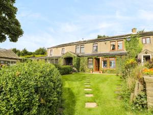 an exterior view of a house with a yard at Upper Highlees Farm in Luddenden Foot