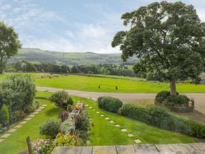 un jardín con un árbol en medio de un campo en Upper Highlees Farm, en Luddenden Foot