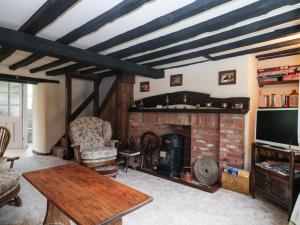 a living room with a fireplace and a tv at Mrs Dale's Cottage in Clenchwarton