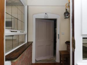 un couloir avec une porte blanche et une fenêtre dans l'établissement Mrs Dale's Cottage, à Clenchwarton 11 autres photos