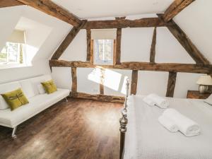 a attic bedroom with a bed and a couch at Lower Tundridge Cottage in Suckley