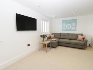 uma sala de estar com um sofá e uma televisão de ecrã plano em Chine Cottage em Sandsend