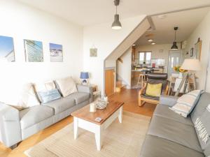 a living room with a couch and a table at 12 West End Point in Pwllheli