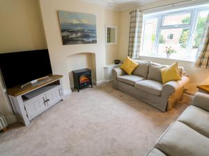 a living room with a couch and a fire place at Nuholme in Stalham