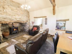 a living room with a couch and a fireplace at Yr Hen Dy in Ffestiniog