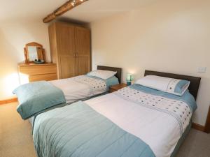 two beds sitting next to each other in a bedroom at Yr Hen Dy in Ffestiniog