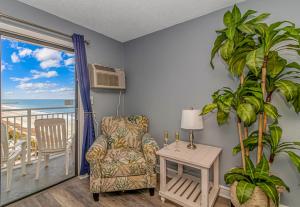 a living room with a chair and a table and a window at Sea Mist 51408 in Myrtle Beach