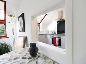 une cuisine avec une table et un vase sur une table dans l'établissement Flintstones, à Buckland St Mary