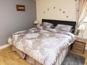 a bedroom with a bed with a white comforter at Knott Lodge in Milnthorpe