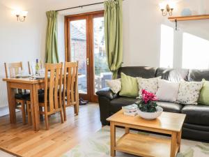 sala de estar con sofá y mesa en Clun Forest Cottage en Monkhopton