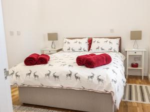 1 dormitorio con 1 cama con almohadas rojas en The Turkey House en Foulden