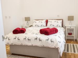 a bedroom with a bed with red pillows at The Turkey House in Foulden