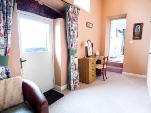 a living room with a door and a chair and a desk at The 'Stables' in Waterfall