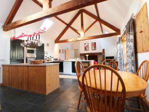 cocina con mesa de madera y sillas de madera en Beudy Mawr, en Llanddeiniolen